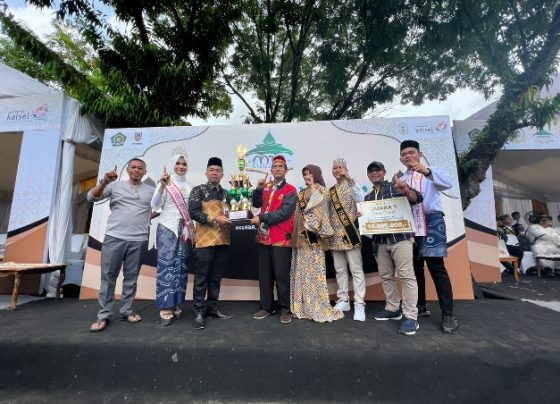 Kadis Pariwisata Kalsel menyerahkan hadiah ke Koordinator Pawai Taaruf Kafilah Kalteng Ridwan