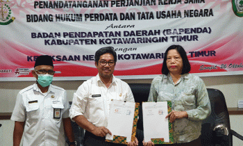 Kepala Bapenda Kotim Ramadhansyah dan Kepala Kejaksaan Negeri Kotim berfoto bersama dan menunjukkan tanda tangan kerjasama.
