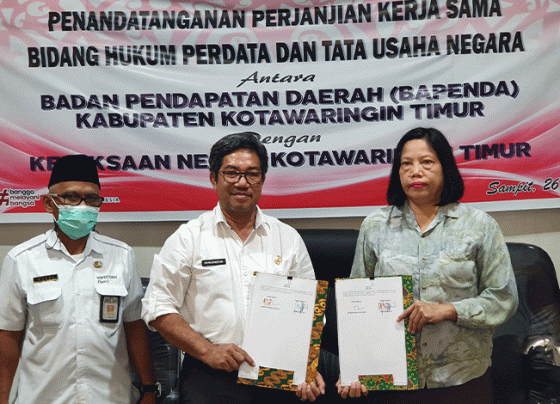 Kepala Bapenda Kotim Ramadhansyah dan Kepala Kejaksaan Negeri Kotim berfoto bersama dan menunjukkan tanda tangan kerjasama.