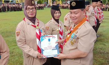 Kepala SMPN 4Sampit Suyatmi menerima Lencana Pancawarsa yang diserahkan Bupati Kotim Halikinnor
