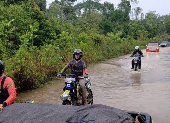 Sejumlah anggota HNR Adventure Trail bersama tim Pemkab Kotim saat melintasi jalan yang dilanda banjir untuk ke desa mengantar paket sembako