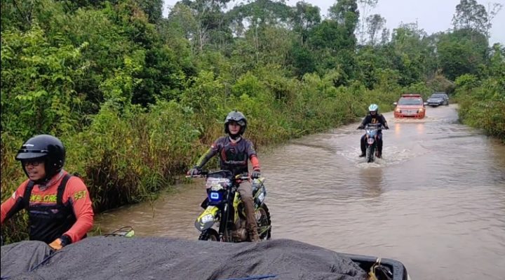 Sejumlah anggota HNR Adventure Trail bersama tim Pemkab Kotim saat melintasi jalan yang dilanda banjir untuk ke desa mengantar paket sembako