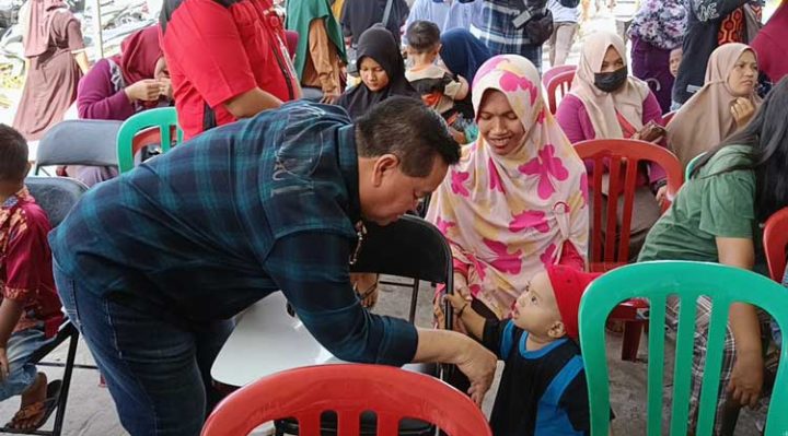 Bupati Kotim Halikinnor saat menyapa warga yang antre membeli paket sembako saat pasar penyeimbang di halaman kantor Pemerintah Desa Pelangsian Kecamatan Mentawa Baru Ketapang Minggu 20 November 2022 .