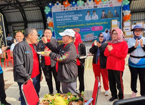 Bupati Kotim Halikinnor satu menyuapkan potongan tumpeng ke Kepala Dinas Kesehatan Umar Kaderi