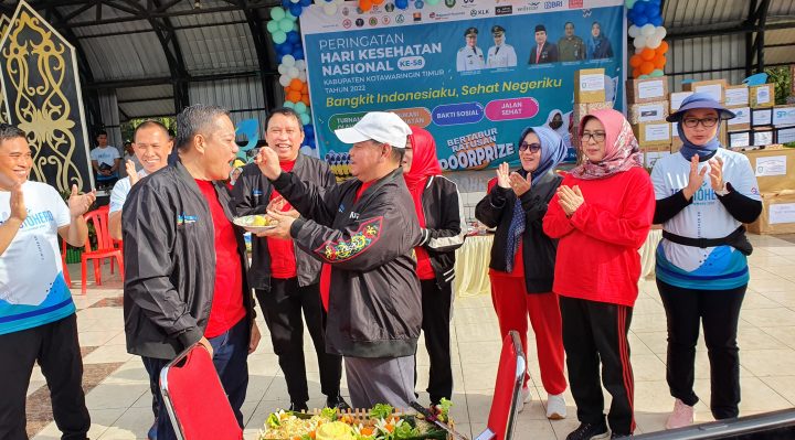 Bupati Kotim Halikinnor satu menyuapkan potongan tumpeng ke Kepala Dinas Kesehatan Umar Kaderi