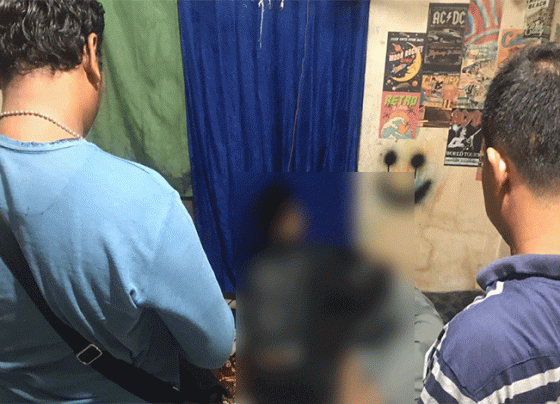 Dua polisi berpakaian preman mengamankan dua sejoli yang digerebek karena melakukan persetubuhan di rumah kosong.