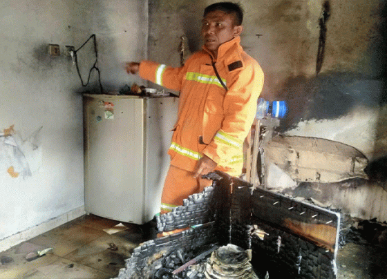 Seorang petugas saat memeriksa kondisi bagian dapur rumah yang terbakar diduga akibat gas bocor.