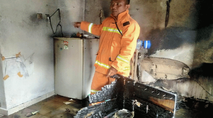 Seorang petugas saat memeriksa kondisi bagian dapur rumah yang terbakar diduga akibat gas bocor.
