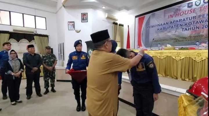 Staf Ahli Bupati Kotim Najmi Fuadi saat mengalungkan kartu tanda peserta In House Training Pemadam Kebakaran Kotim tahun 2022 di Aula Sei Mentaya Bapelitbangda Kotim Senin 28 November 2022.