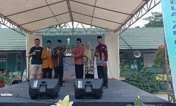 Kasi Kurikulum dan Pembinaan SMP Disdik Kotim Suyoso menyerahkan penghargaan Gelar Juara Umum kepada perwakilan MIN 1 Kotim Syadillah.