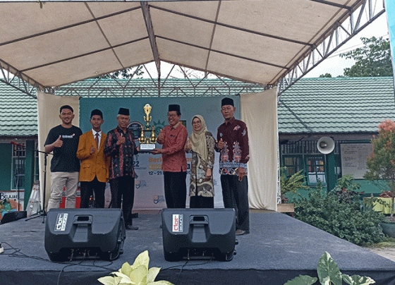 Kasi Kurikulum dan Pembinaan SMP Disdik Kotim Suyoso menyerahkan penghargaan Gelar Juara Umum kepada perwakilan MIN 1 Kotim Syadillah.