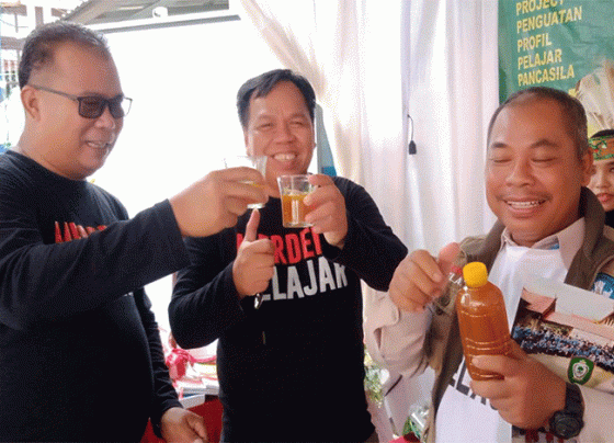 Momen Kabid Pembinaan SD Disdik Kotim Agus Wahyudi tengah menyicipi minuman jamu tradisional hasil belajar P5 Siswa SDN 2 Sawahan Selasa 27 Desember 2022.