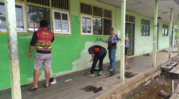 Rider HNR Trail Adventure Kotim mengecat bangunan Pondok Pesantren Darul Iman di Kecamatan Pulau Hanaut.