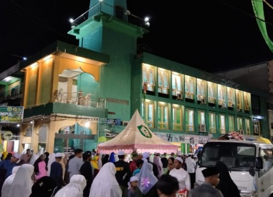 Jemaah Haul Guru Sekumpul laksankan salat isya berjamaah di bawah guyuran hujan Sabtu 28 Januari 2023.