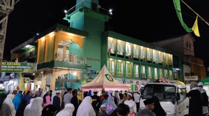 Jemaah Haul Guru Sekumpul laksankan salat isya berjamaah di bawah guyuran hujan Sabtu 28 Januari 2023.