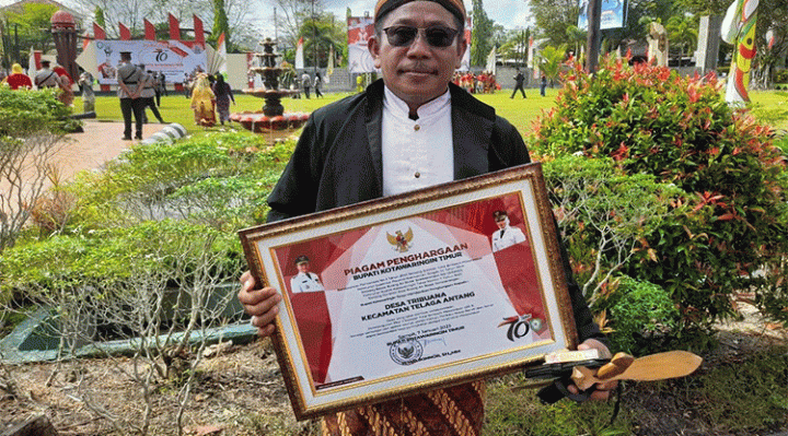 Kepala Desa Tribuana Kecamatan Telaga Antang Achmad Badirun menerima penghargaan sanitasi berbasis masyarakat 100 setelah desanya menerapkan program jamban sehat.