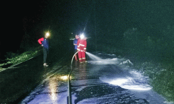 Petugas ketika membersihkan tumpahan solar di Jalan trans Kalimantan Desa Gohong Pulang Pisau usai kecelakaan Kamis malam 26 Januari 2023. 1