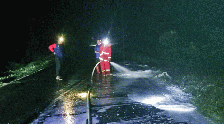 Petugas ketika membersihkan tumpahan solar di Jalan trans Kalimantan Desa Gohong Pulang Pisau usai kecelakaan Kamis malam 26 Januari 2023. 1