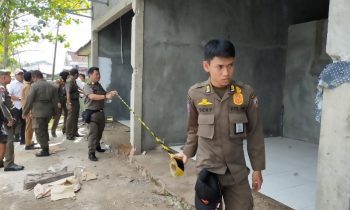 Sejumlah anggota Satpol PP Kotim saat memasang garis kuning hitam milik DPUPRPRKP di ruko yang melanggar Perda Tibum Senin 9 Januari 2023.