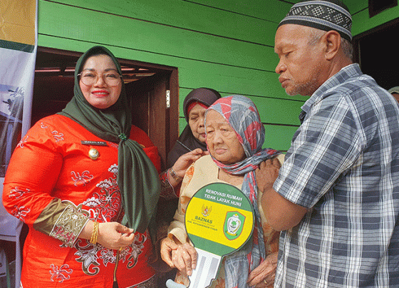 Wakil Bupati Kotim Irawati saat memberikan kunci rumah Ibu Hadijah salah satu penerima manfaat program renovasi didampingi keluarganya.