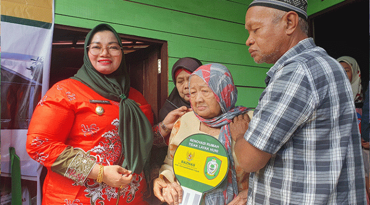 Wakil Bupati Kotim Irawati saat memberikan kunci rumah Ibu Hadijah salah satu penerima manfaat program renovasi didampingi keluarganya.