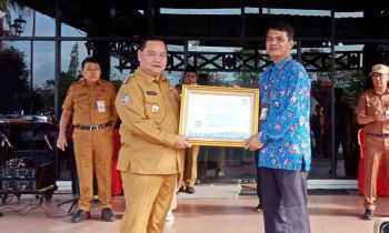 Bupati Kotim Halikinnor saat menerima penghargaan kepatuhan terhadap standar pelayanan publik dari Ombusman RI Perwakilan Kateng Raden Biroum