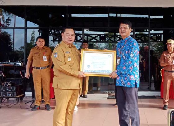 Bupati Kotim Halikinnor saat menerima penghargaan kepatuhan terhadap standar pelayanan publik dari Ombusman RI Perwakilan Kateng Raden Biroum