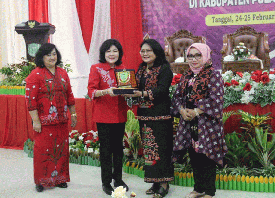 Bupati Pulang Pisau Pudjirustaty Narang didampingi ketua TP PKK Pulang Pisau menyerahkan palakat kepada Dewan Pembina IGC dan Ketua Wanita Keren Indonesia.