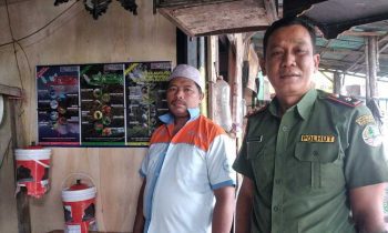 Komandan BKSDA Pos Jaga Sampit bersama pedagang usai memasang poster di kios sekitar hutan kota.