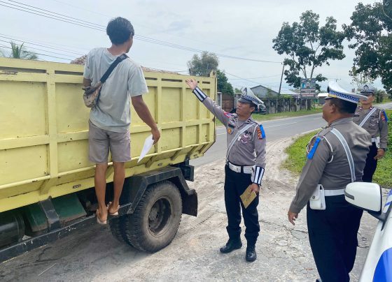 Personel Ditlantas Polda Kalteng saat mensosialisasikan imbauan untuk menutup muatan material kepada sejumlah sopir truk di Palangka Raya.