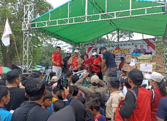 Salah satu peserta Jalan Sehat PGRI Kotim yang mendapatkan undian doorprize sepeda berfoto bersama Bupati Kotim Halikinnor Minggu 5 Februari 2023.