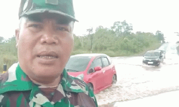 Seorang aparat TNI dari Kodim 1019 Katingan mengatur arus lalulintas di Jalan Trans Kakimantan Km 18 5 Kereng Pangi Sampit yang tergenang akibat hujan lebat Selasa 28 Februari 2023.
