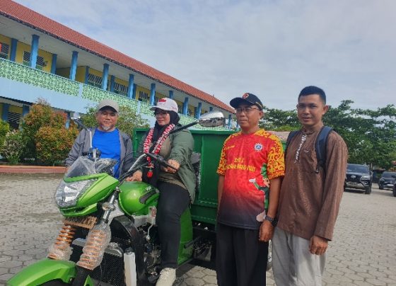 Wakil Bupati Kotim Irawati saat mengendarai motor roda tiga didampingi Kepala DLH Machmoer dan Kepala Sekolah SDN 3 MB Hulu .