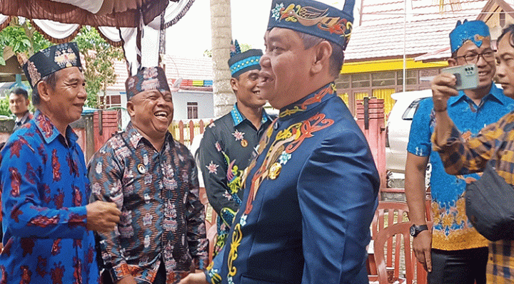Bupati Kotim Halikinnor baju biru gelap saat menghadiri pelantikan Damang Kepala Adat Baamang Kamis 2 Maret 2023.