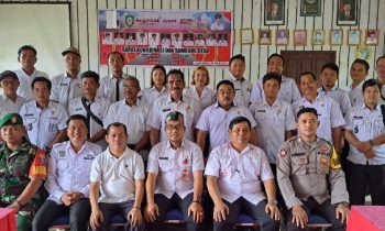 Kepala DPMD Kotim Raihansyah tengah pakai peci berfoto bersama dengan camat dan kepala desa di Kecamatan Tualan Hulu.