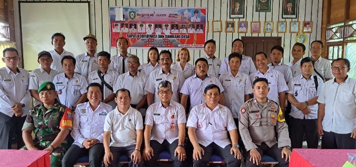 Kepala DPMD Kotim Raihansyah tengah pakai peci berfoto bersama dengan camat dan kepala desa di Kecamatan Tualan Hulu.