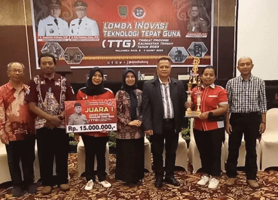 Perwakilan SMKN 4 Sampit memegang piala Juara 1 saat berfoto bersama.