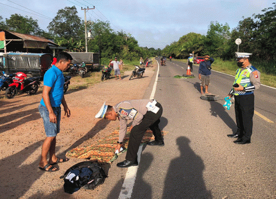 Polisi menutup mayat korban meninggal dengan kain jarik di lokasi kecelakaan di Jalan Jendaral Sudirman Km 26.