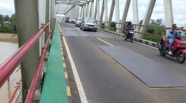 Sejumlah kendaraan melintas di Jembatan Sei Katingan di Kasongan yang sebagian aspalnya masih ditutupi beberapa lembar pelat besi untuk menutup lubang.