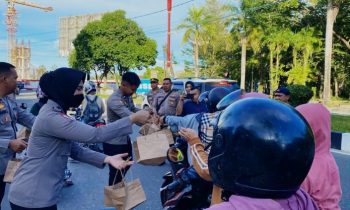 Sejumlah personel Polda Kalteng membagikan paket takjil kepada sekumlah warga yang melintas di Bundaran Besar Palangka Raya Kamis 23 Maret 2023.