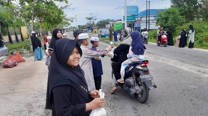 Siswa siswi SDIT Al Madaniyah Samuda turun ke jalan membagikan takjil gratis bagi masyarakat yang melintas di Jalan Partoe Muksin Samuda.