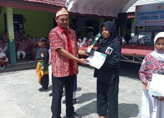 Siswi SDN 4 Baamang Tengah Penti Prisilawati menerima penghargaan juara 1 pencak silat O2SN Baamang di SDN 9 Bamang Tengah Kamis 9 Maret 2023