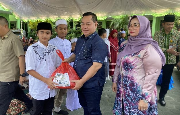 Bupati Kotim Halikinnor menyerahkan bantuan paket sembako dari siswa SDN 2 MB Hulu kepada salah seorang siswa lainnya