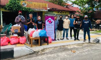 Para pemuda berbagi kasih saat berfoto bersama sebelum membagikan takjil di tepi jalan