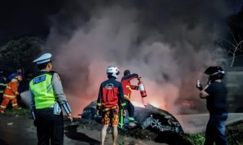 Petugas berusaha memadamkan kobaran api yang membakar sebuah mobil di Jalan Tjilik Riwut, depan SPBU Nor Ain, Sampit, Kamis malam, 27 April 2023.