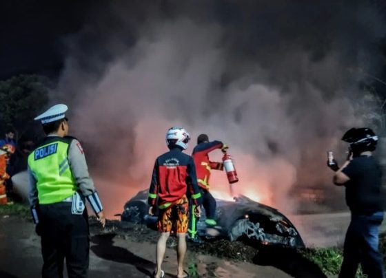 Petugas berusaha memadamkan kobaran api yang membakar sebuah mobil di Jalan Tjilik Riwut, depan SPBU Nor Ain, Sampit, Kamis malam, 27 April 2023.