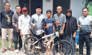 Bupati Kotawaringin Timur menyerahkan bantuan 1 unit sepeda kepada Hendra.