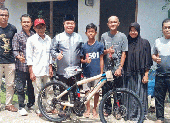 Bupati Kotawaringin Timur menyerahkan bantuan 1 unit sepeda kepada Hendra.