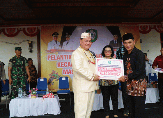 Bupati Kotim Halikinnor didampingi Ketua DPRD Rinie saat menyerahkan dana hibah salah satu rumah ibadah di Kecamatan Mentaya Hulu.