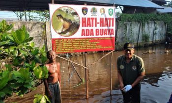 Komandan BKSDA Pos Jaga Sampit Muriansyah bersama warga usai memasang ppan peringatan keberadaan buaya di Sungai Mentawa, Rabu, 31 Mei 2023.